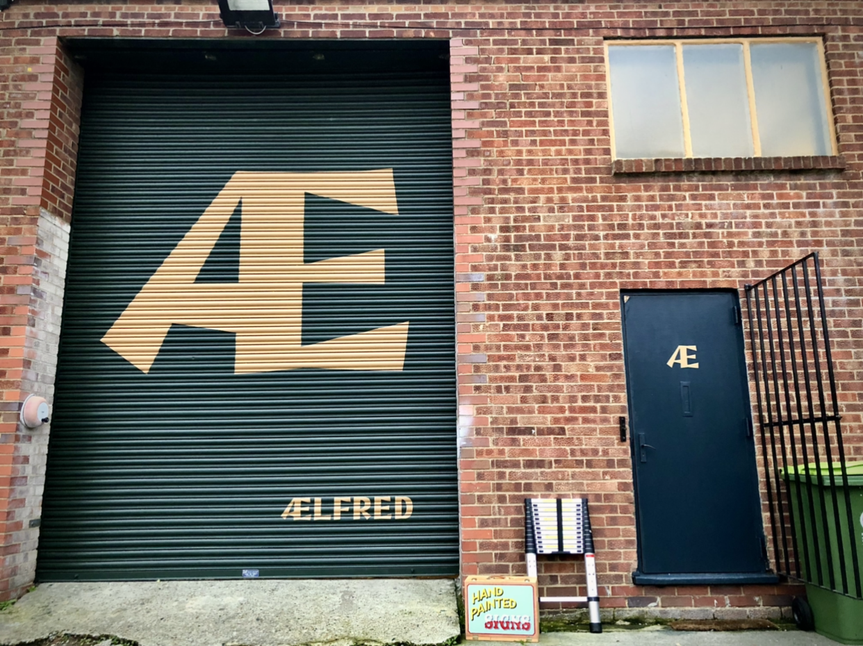 Bespoke hand-painted high street garage door mural and logo for the Ælfred Nordic furniture showrooms.