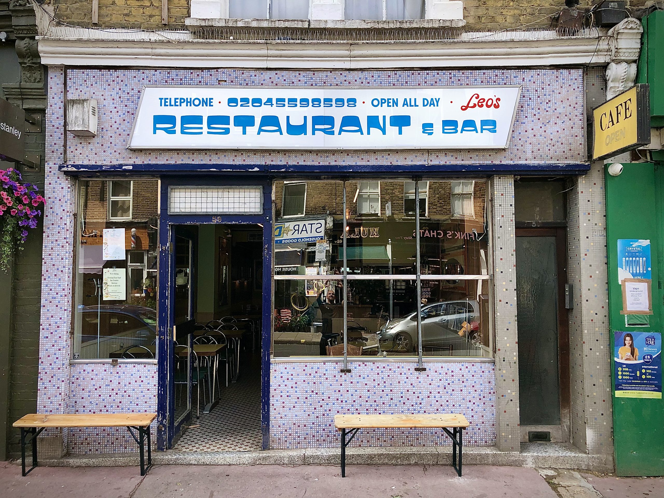 Retro-style shop sign for Leo's restaurant and bar. Street view.